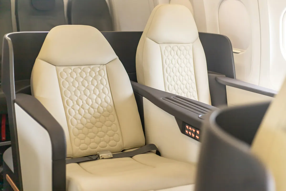 Cream leather club seat with quilted stitching in a private jet cabin