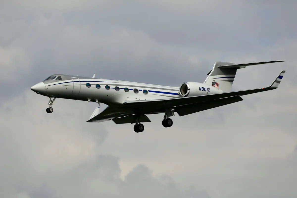 Long-range Gulfstream business jet in flight above grey cloud